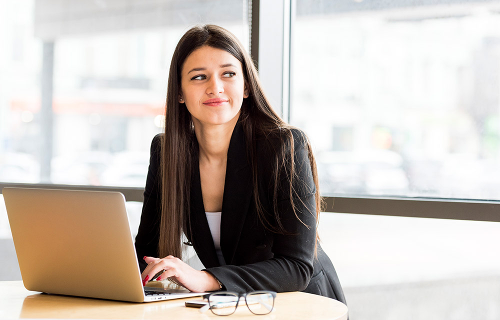 The image shows two girls sitting in front of their laptop sharing an envelope containing message